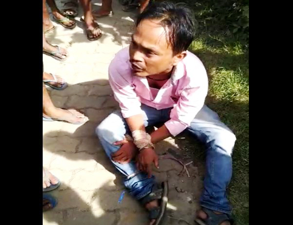 Screen grab from the viral video that shows Shantanu Borgohain with his hands tied at Namti Bazaar.